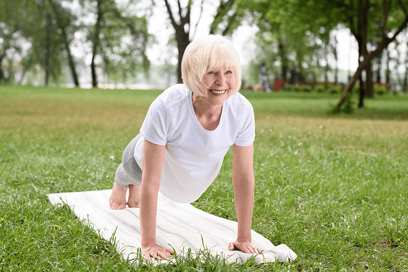 smiling-elderly-woman-doing-plank-yoga-mat-1